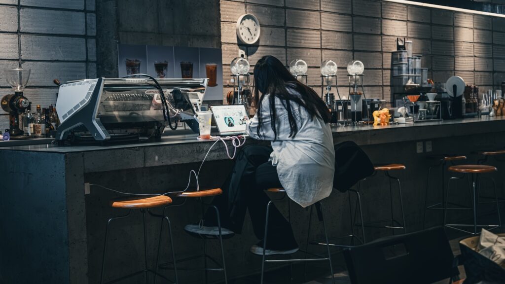 a woman sitting at a bar with a laptop