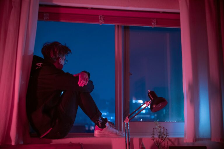 woman in black jacket sitting on window